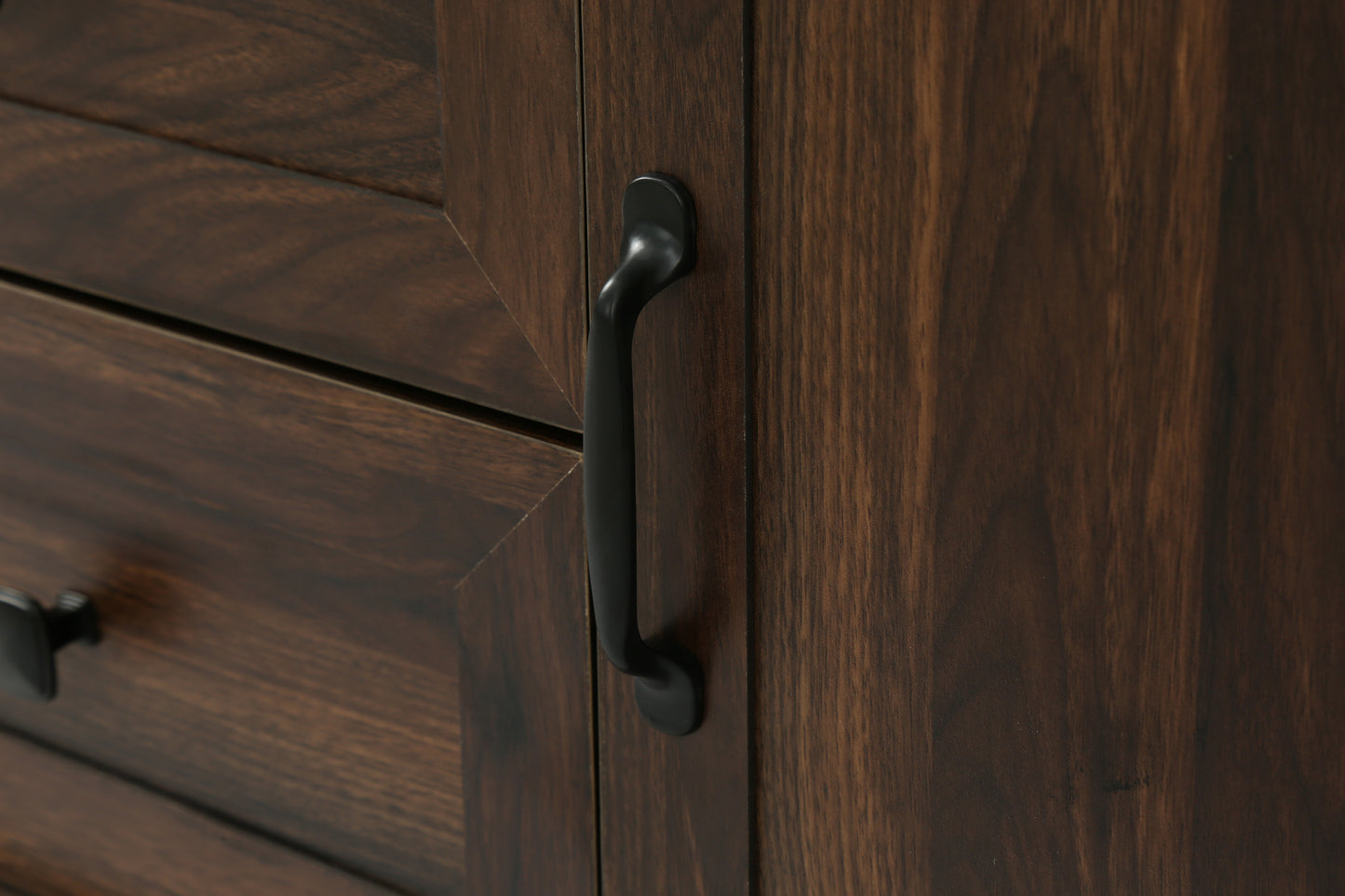 Dark wood dresser drawer front with angled plank design and black handle