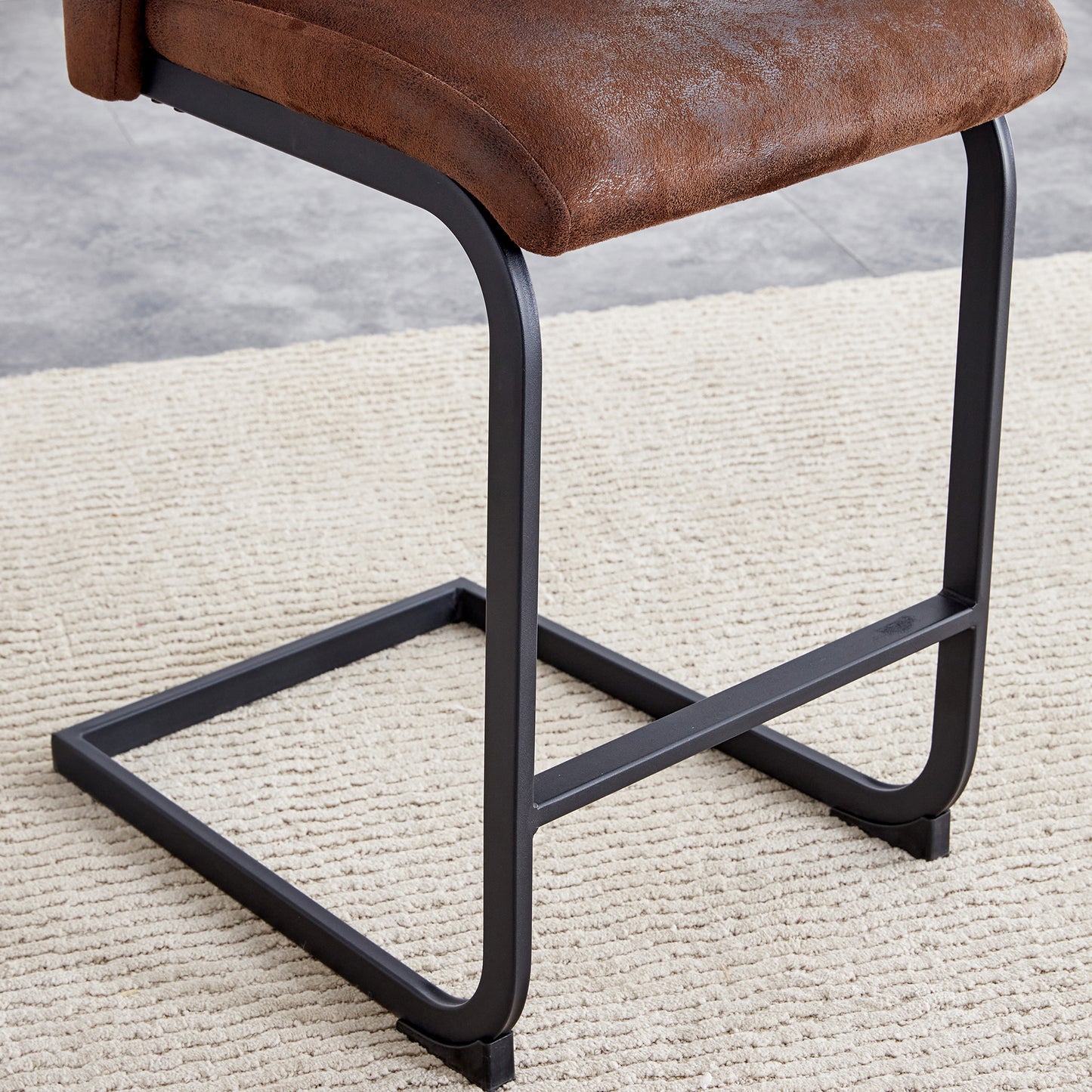 Brown faux leather counter stool with black metal legs on a cream rug