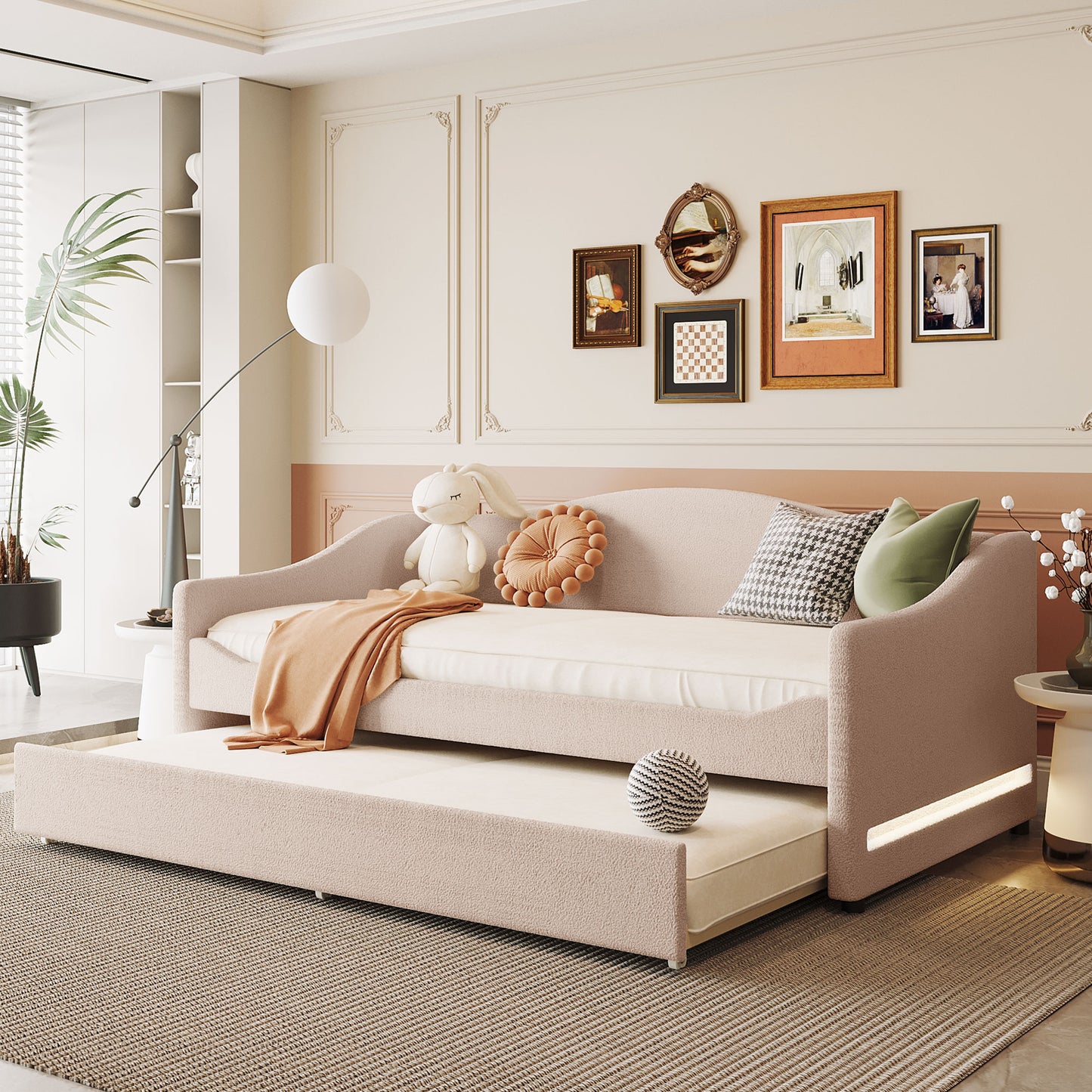 Upholstered twin daybed with trundle in soft pink fabric featuring curved arms and LED lighting