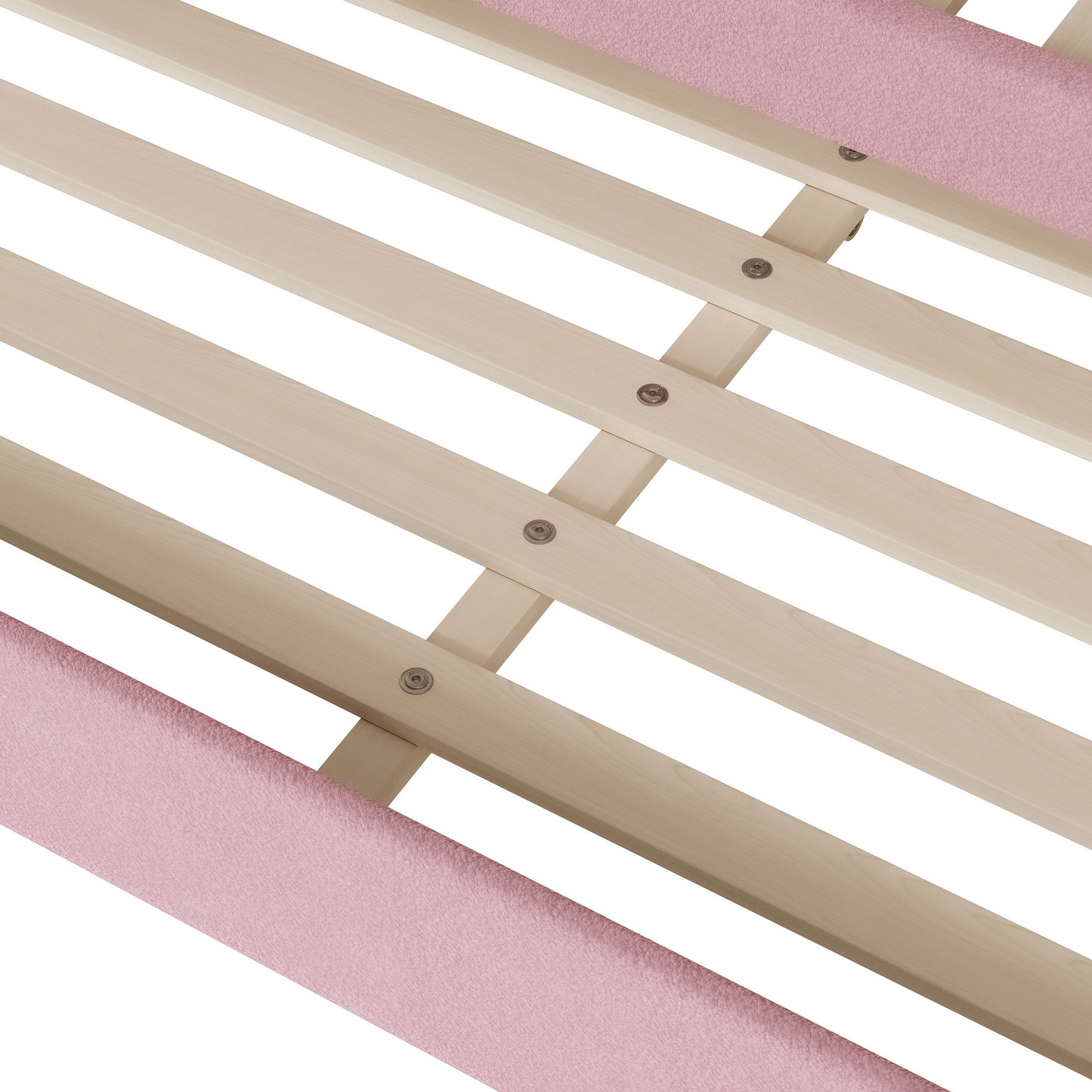 Closeup of a pink upholstered bed frame edge with light wood slats