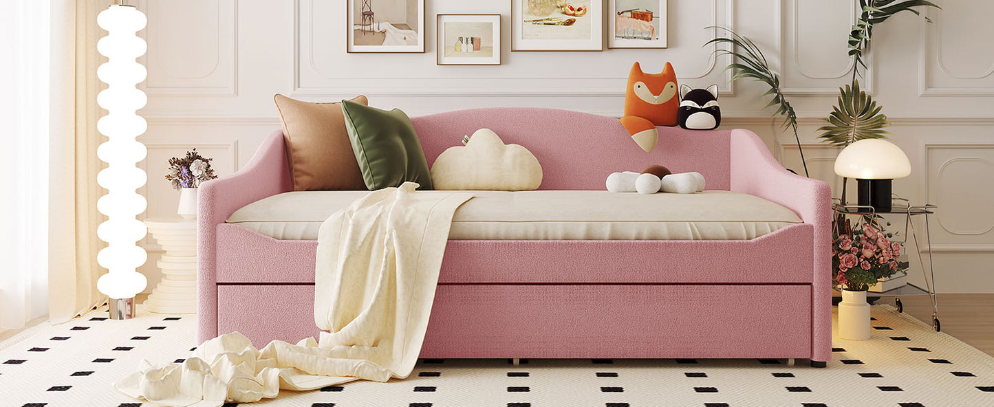 Pink upholstered daybed with cream mattress and pullout trundle
