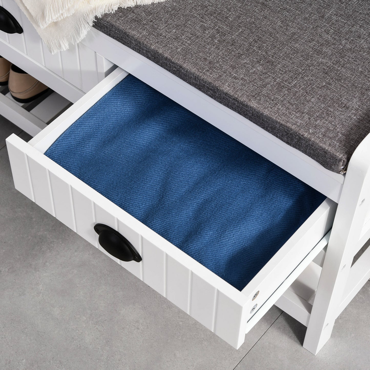 White shoe bench with grey cushioned seat and open blue drawer