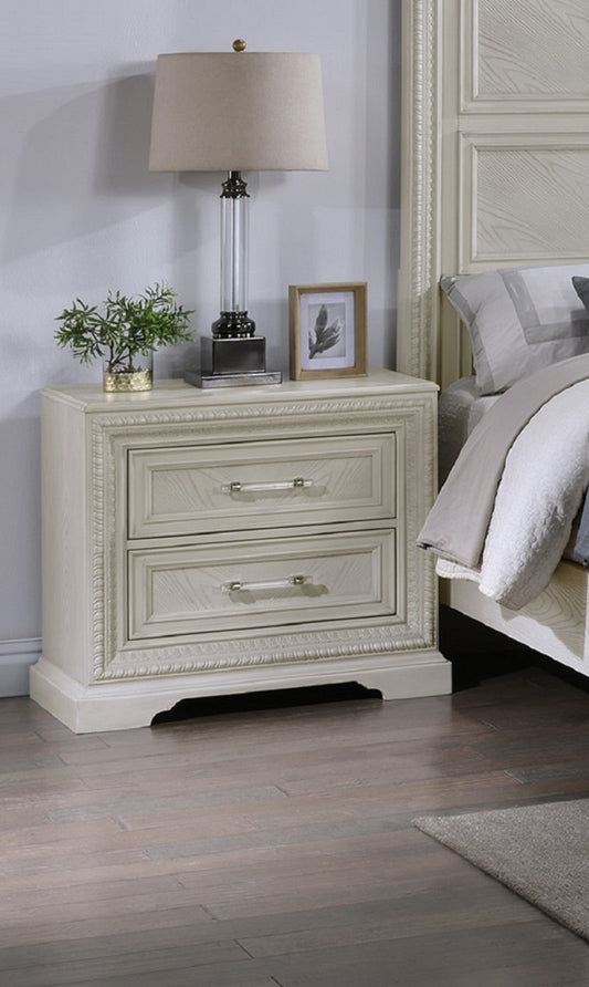 Cream painted wood nightstand with two drawers and ornate trim