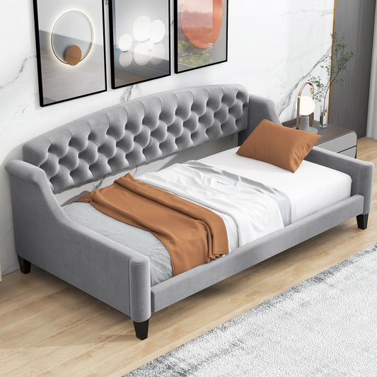 Grey velvet tufted daybed with plush cushions and a copper throw blanket