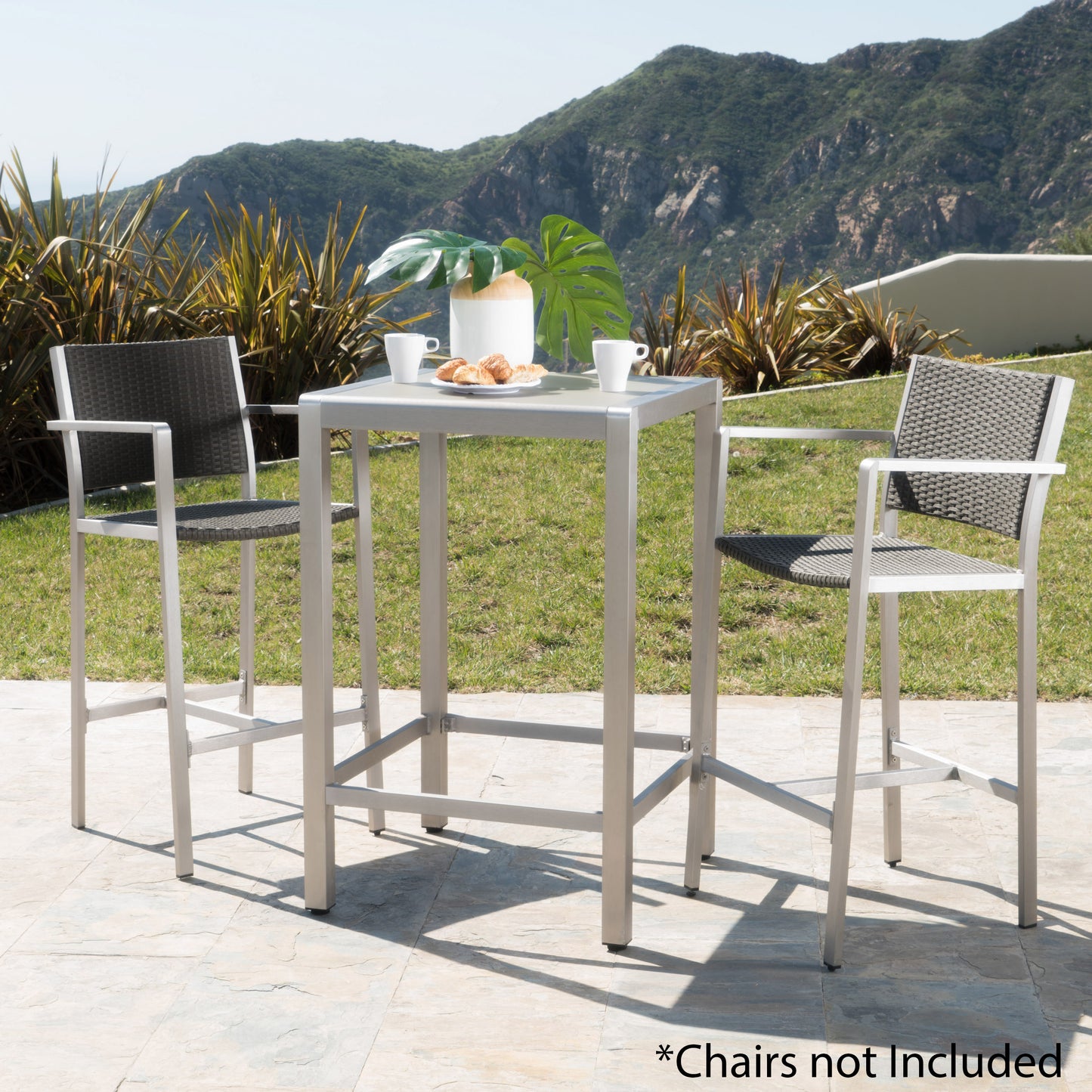 Silver aluminum bar table with woven gray seats and white mugs