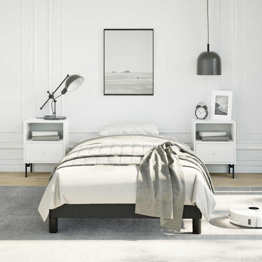 Modern black metal twin bed frame with white bedding and grey throw