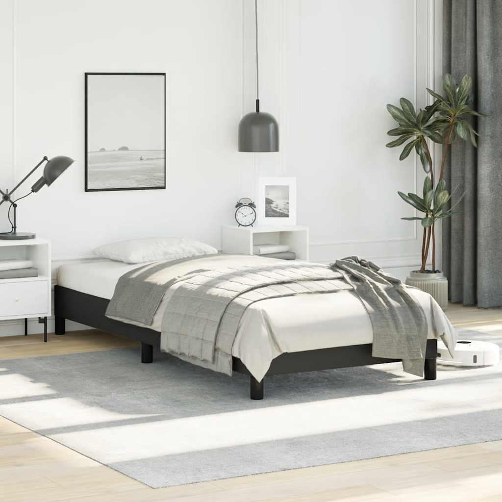 Dark grey metal twin bed frame with white bedding and a quilted throw blanket