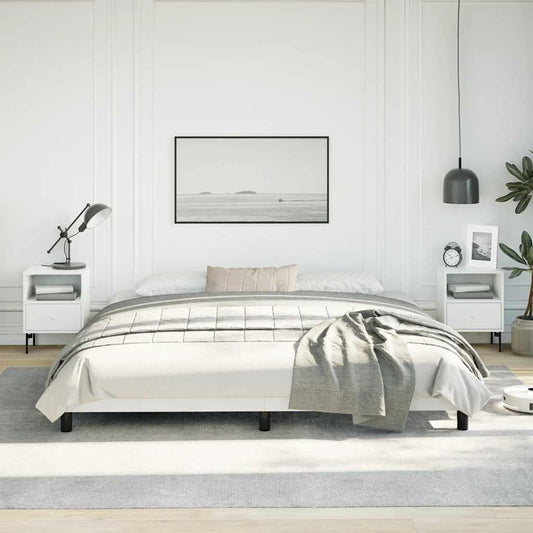 Modern white metal platform bed frame with grey throw blanket and bedside table