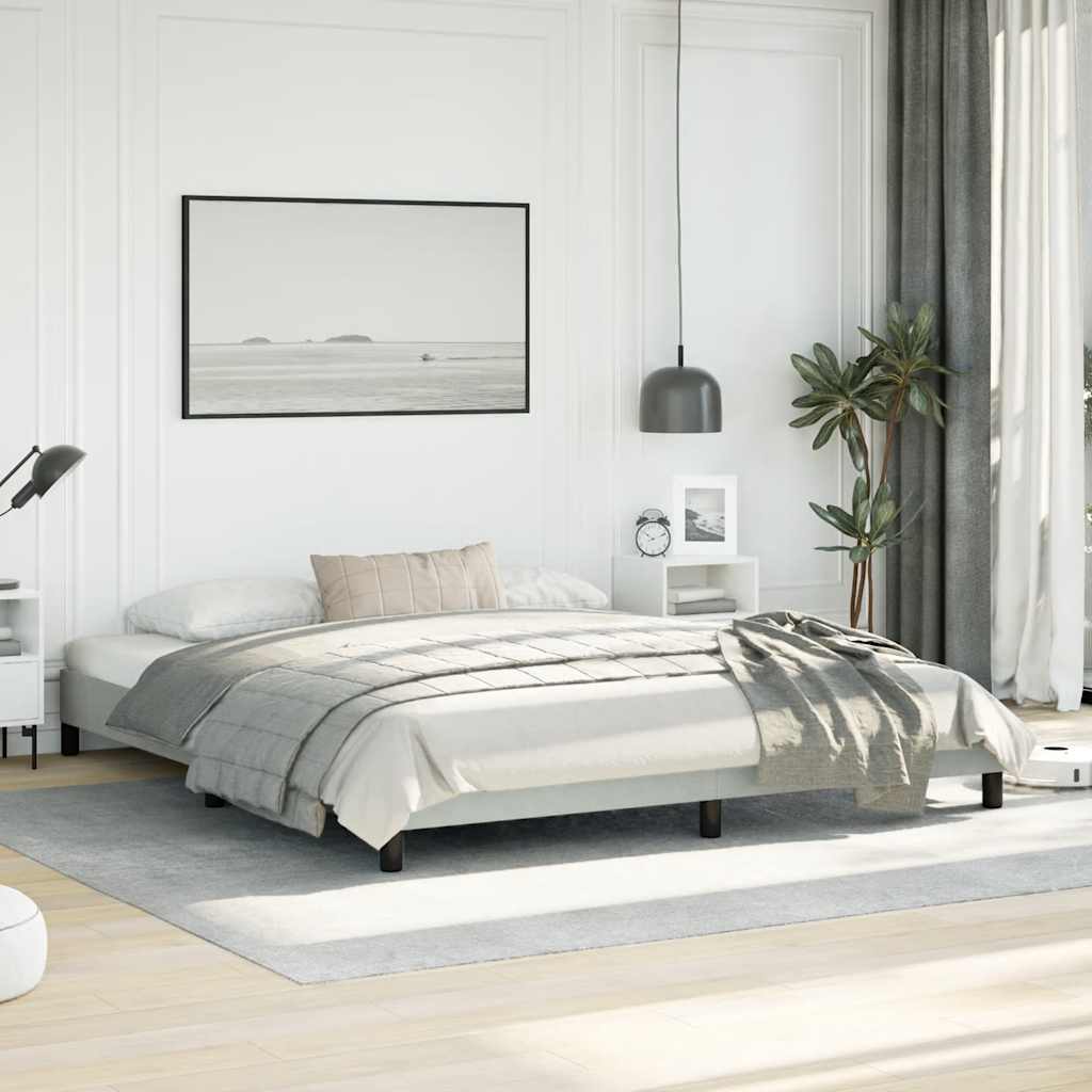 Modern platform bed frame with black metal legs and a white upholstered headboard