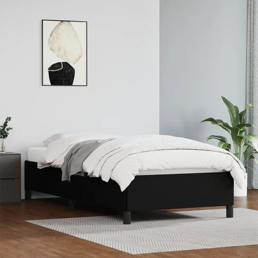 Modern black upholstered twin bed frame with grey bedding and a white mattress