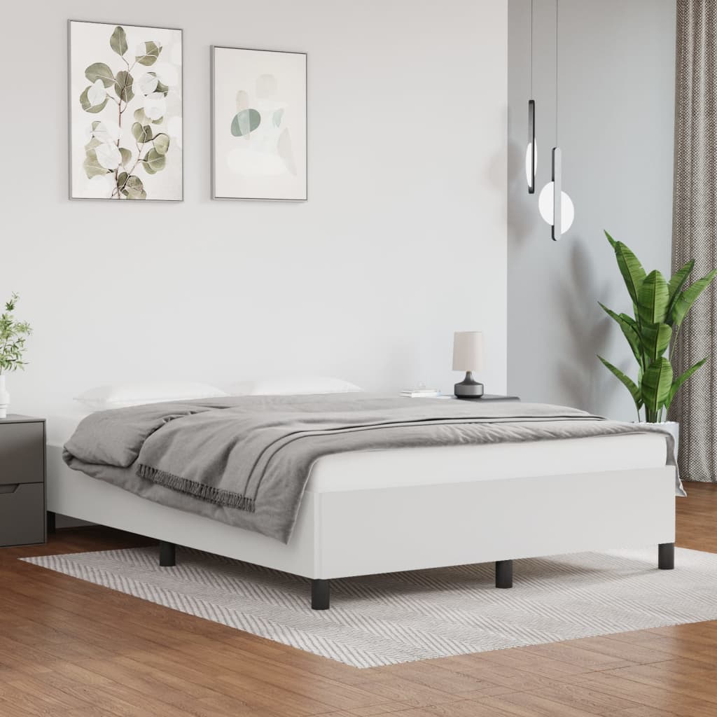 White upholstered twin bed frame with a quilted grey throw blanket