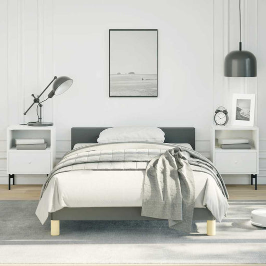 Gray upholstered platform bed frame with white bedding and a gray throw blanket