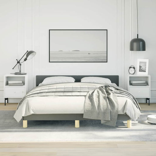 Grey upholstered platform bed with white bedding and grey throw blanket