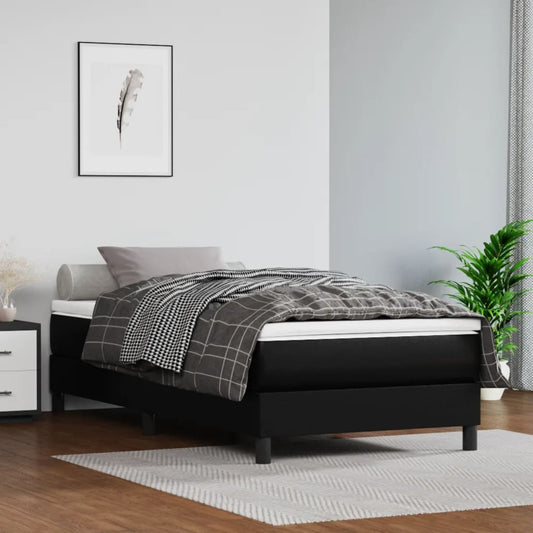 Black upholstered divan bed with a grey grid duvet and pillow