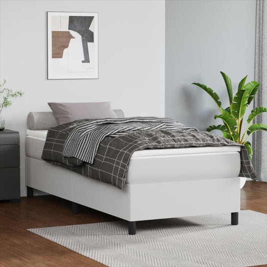 White upholstered single bed frame with gray plaid bedding and abstract art