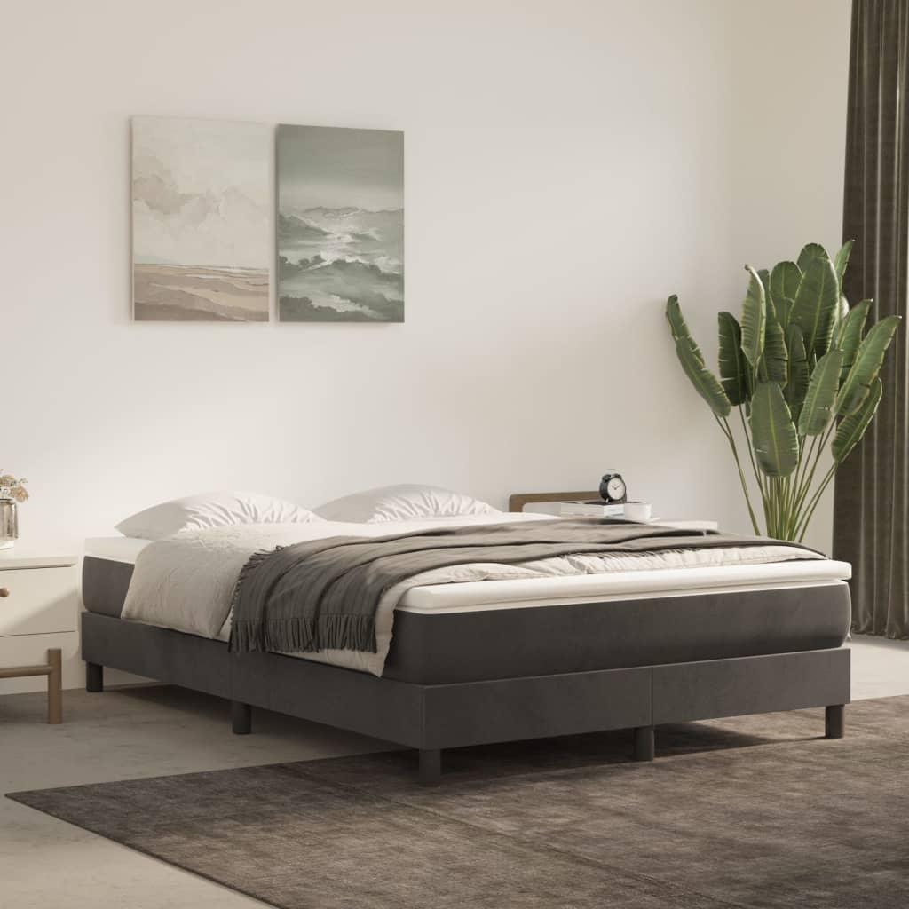 Dark grey upholstered bed frame with a white mattress and grey throw blanket