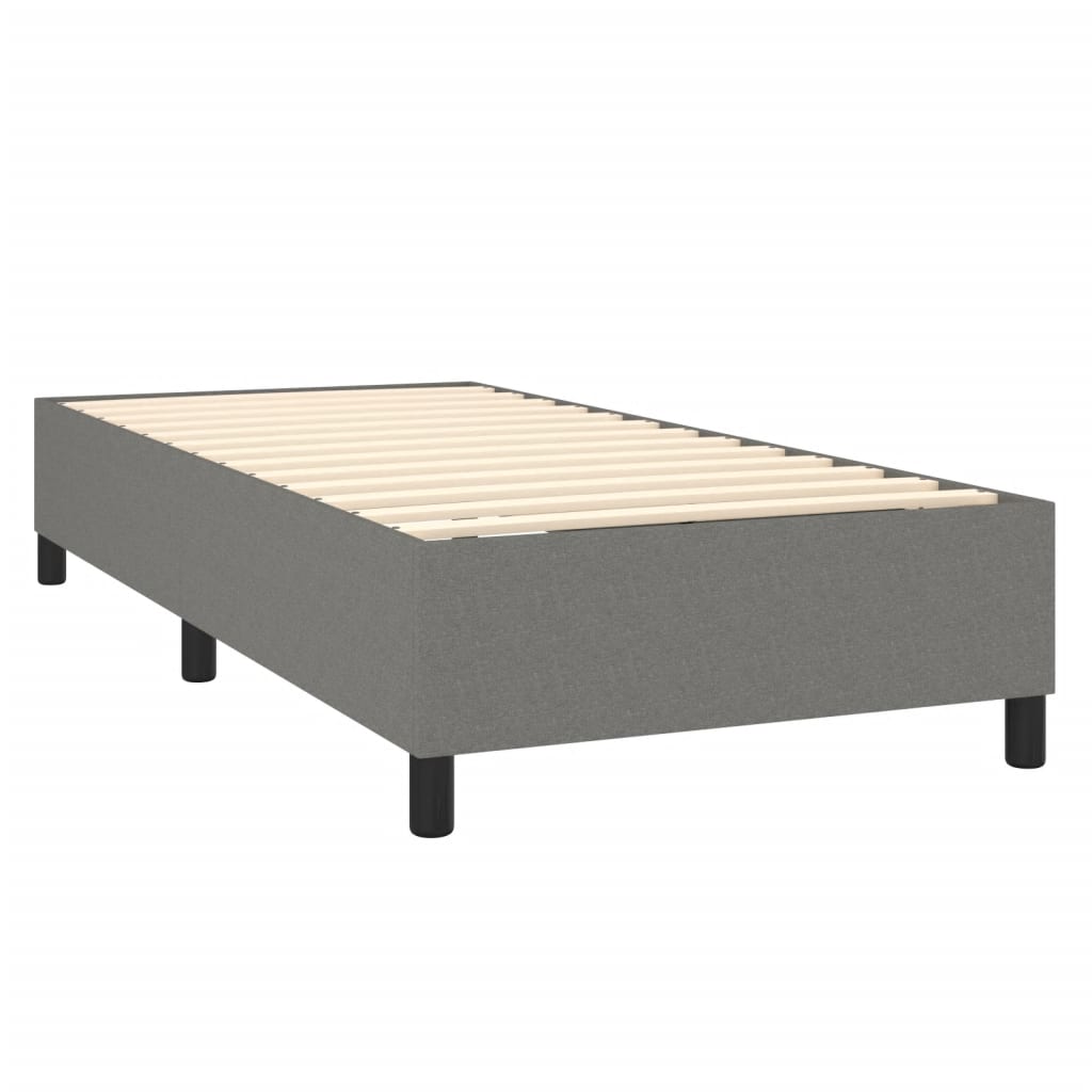 Grey upholstered divan bed base with white mattress topper and black legs