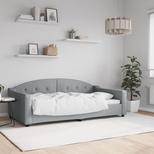 Grey upholstered daybed with tufted back and studded trim