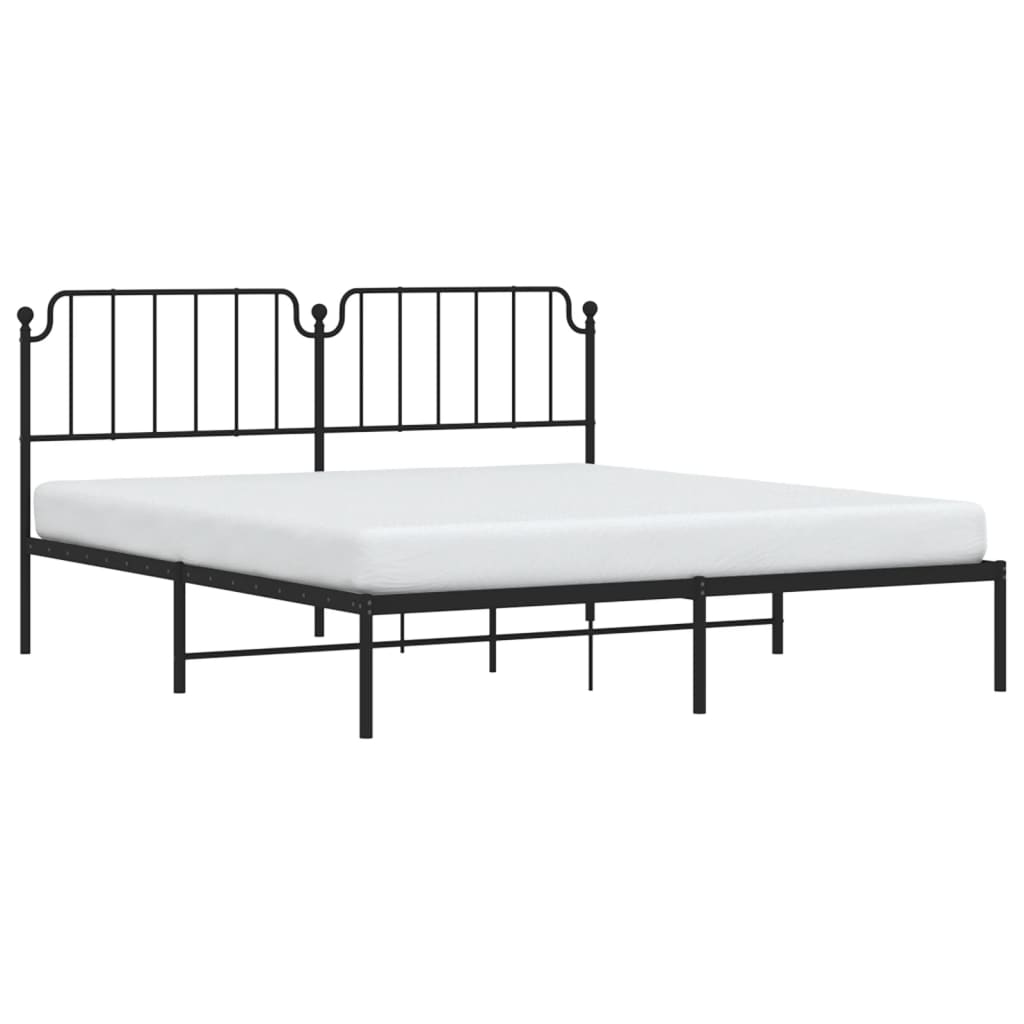 Black metal bed frame with ornate headboard and white mattress