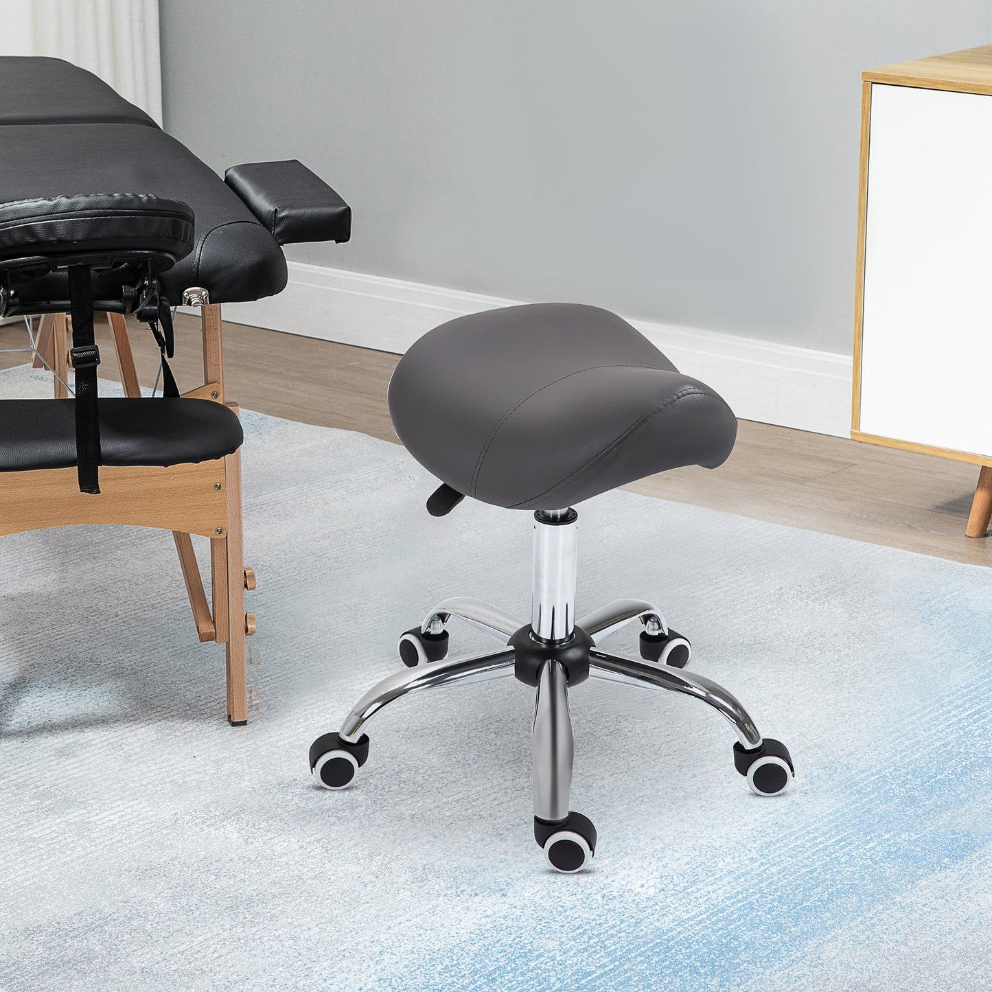 Dark gray ergonomic saddle stool with adjustable height and casters