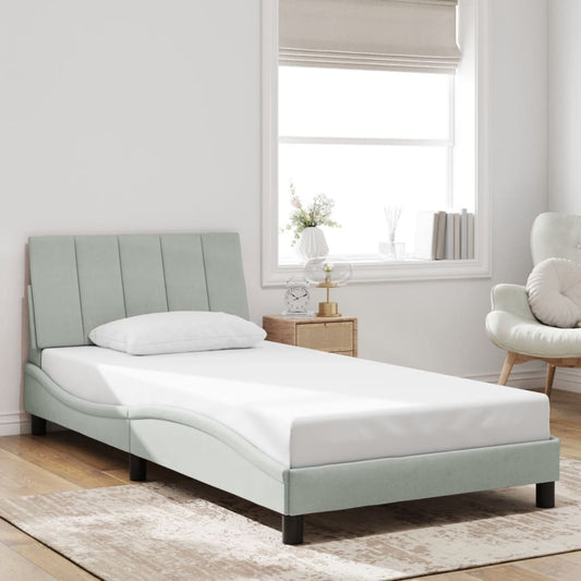 Light blue upholstered twin bed frame with padded headboard and white mattress