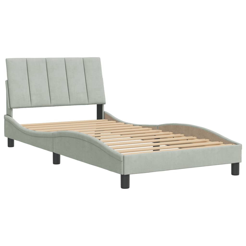 Light grey upholstered twin bed with a curved frame and tufted headboard