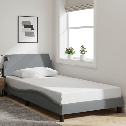 Gray upholstered twin bed frame with white mattress and pillow