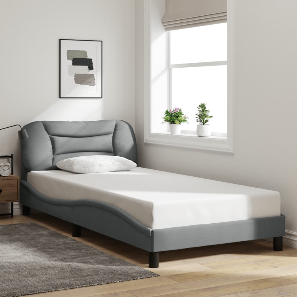 Grey upholstered modern bed frame with a curved headboard and slatted base