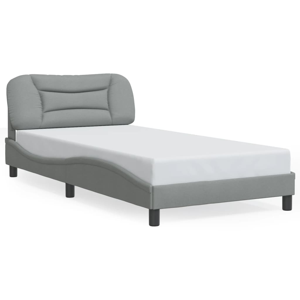 Grey upholstered twin bed with a curved headboard and white mattress
