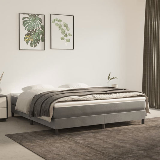 Modern grey upholstered bed frame with plush mattress and draped blanket