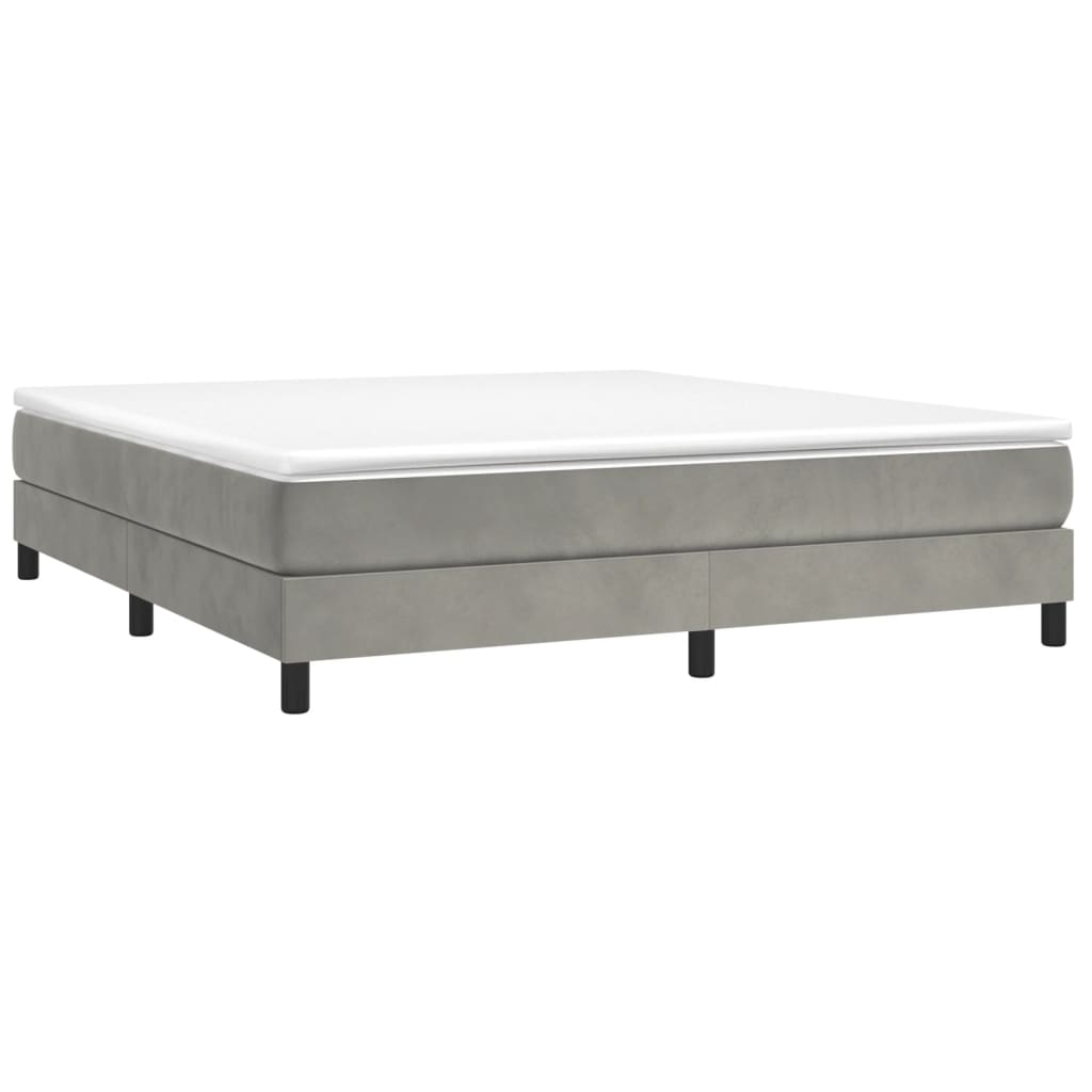 Gray upholstered divan bed base with white mattress topper