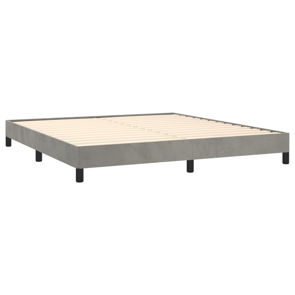 Grey upholstered box spring bed with white mattress top