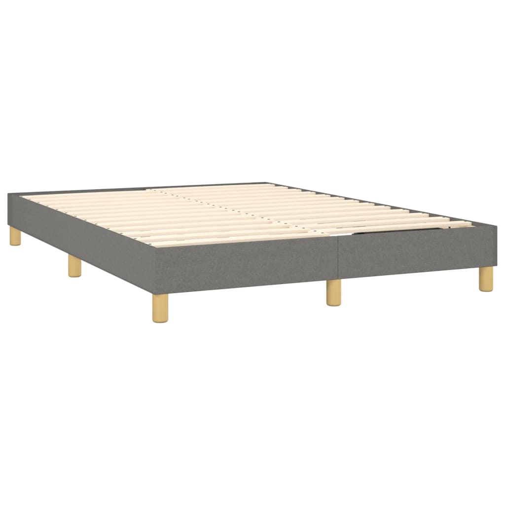 Grey upholstered bed frame with a white mattress and wooden legs