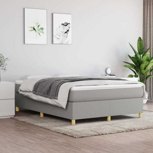 Grey upholstered divan bed with a white mattress and grey throw