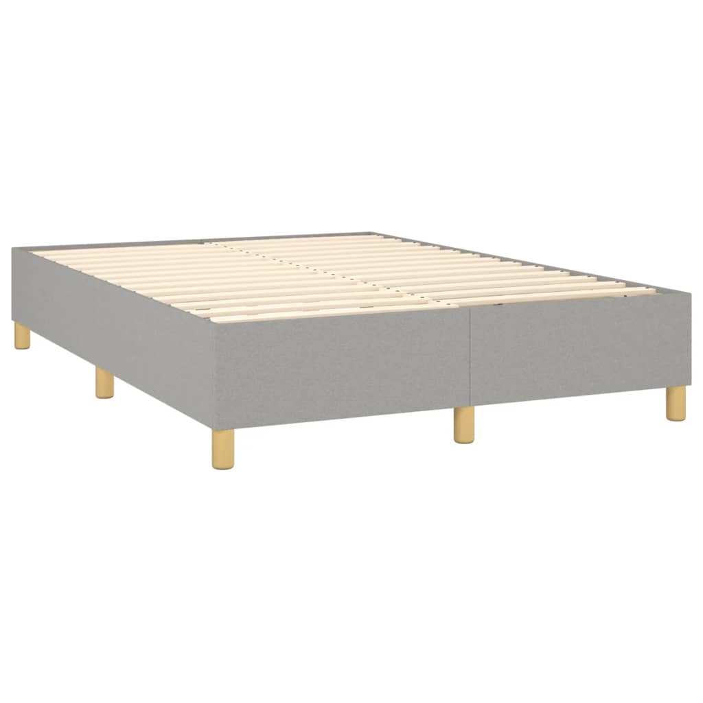 Gray upholstered divan bed base with white mattress and wooden legs