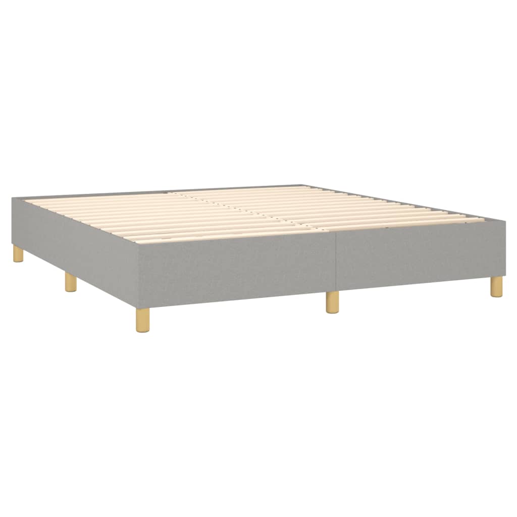 Modern gray upholstered bed base with white mattress and gold legs