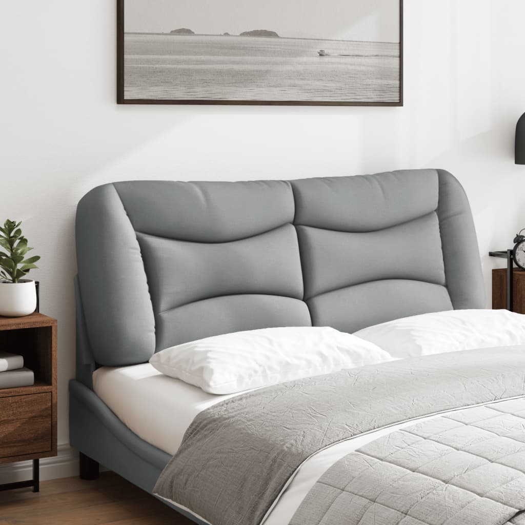 Grey upholstered headboard with plush cushioning and curved design