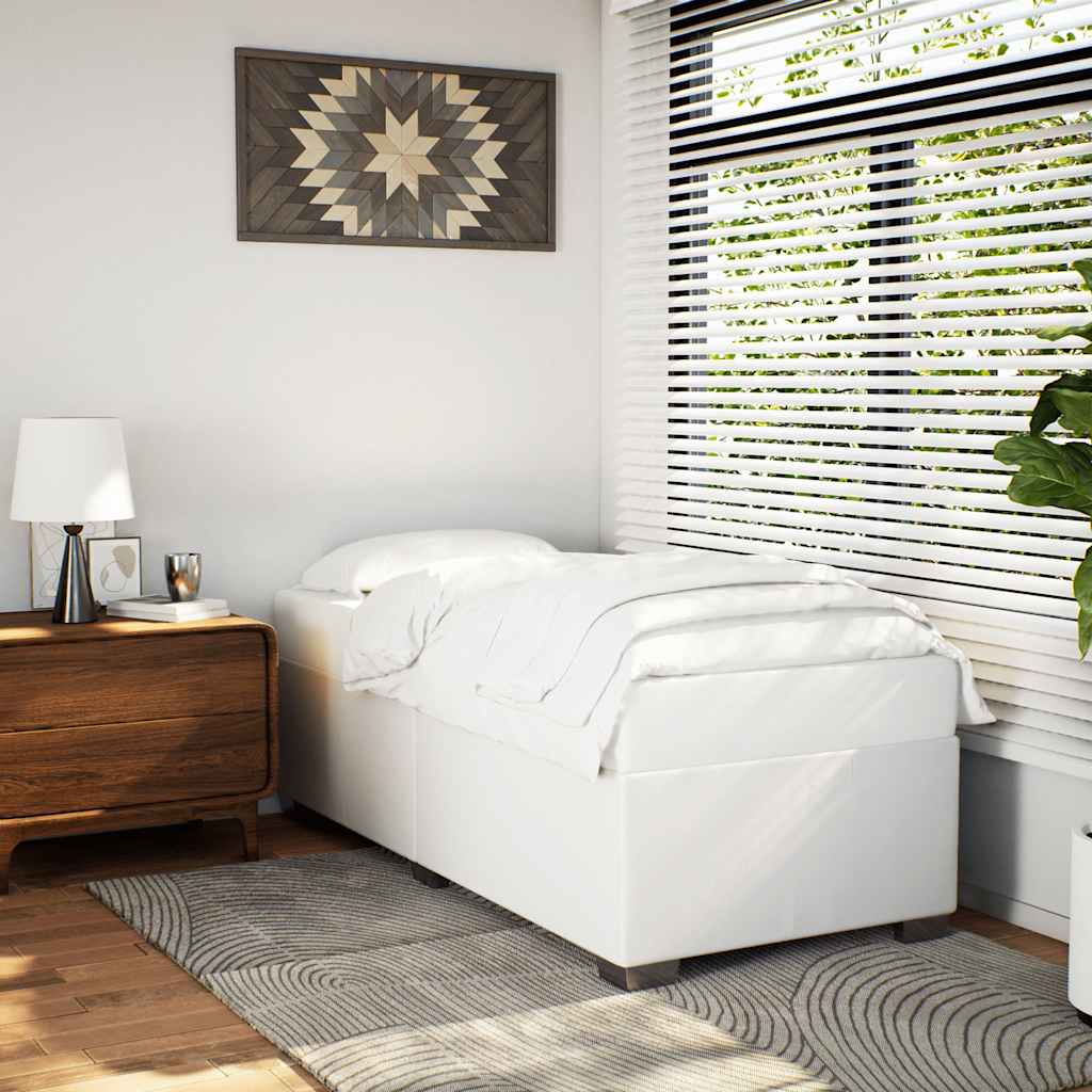 White upholstered bed base with crisp white linens in a modern bedroom setting