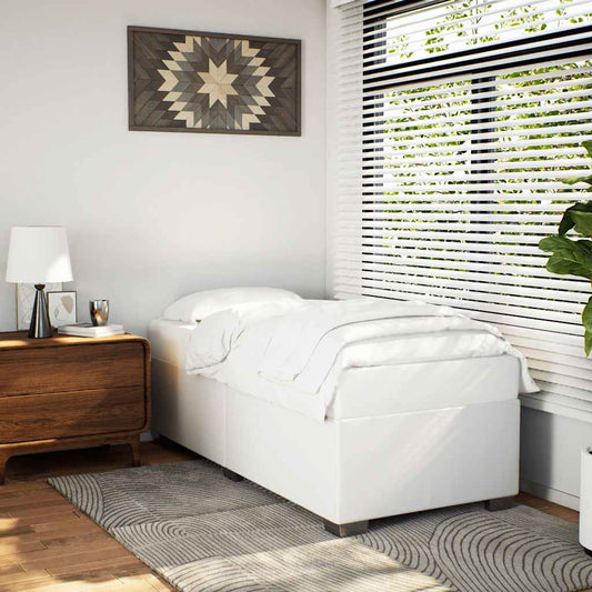 White upholstered bed base with crisp white linens in a modern bedroom setting