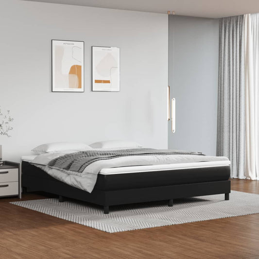 Black upholstered bed frame with white bedding and a grey throw blanket