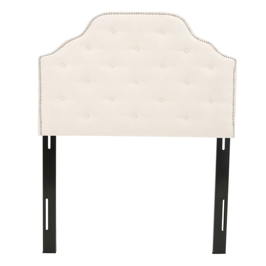 Cream upholstered headboard with tufted buttons and nailhead trim detail