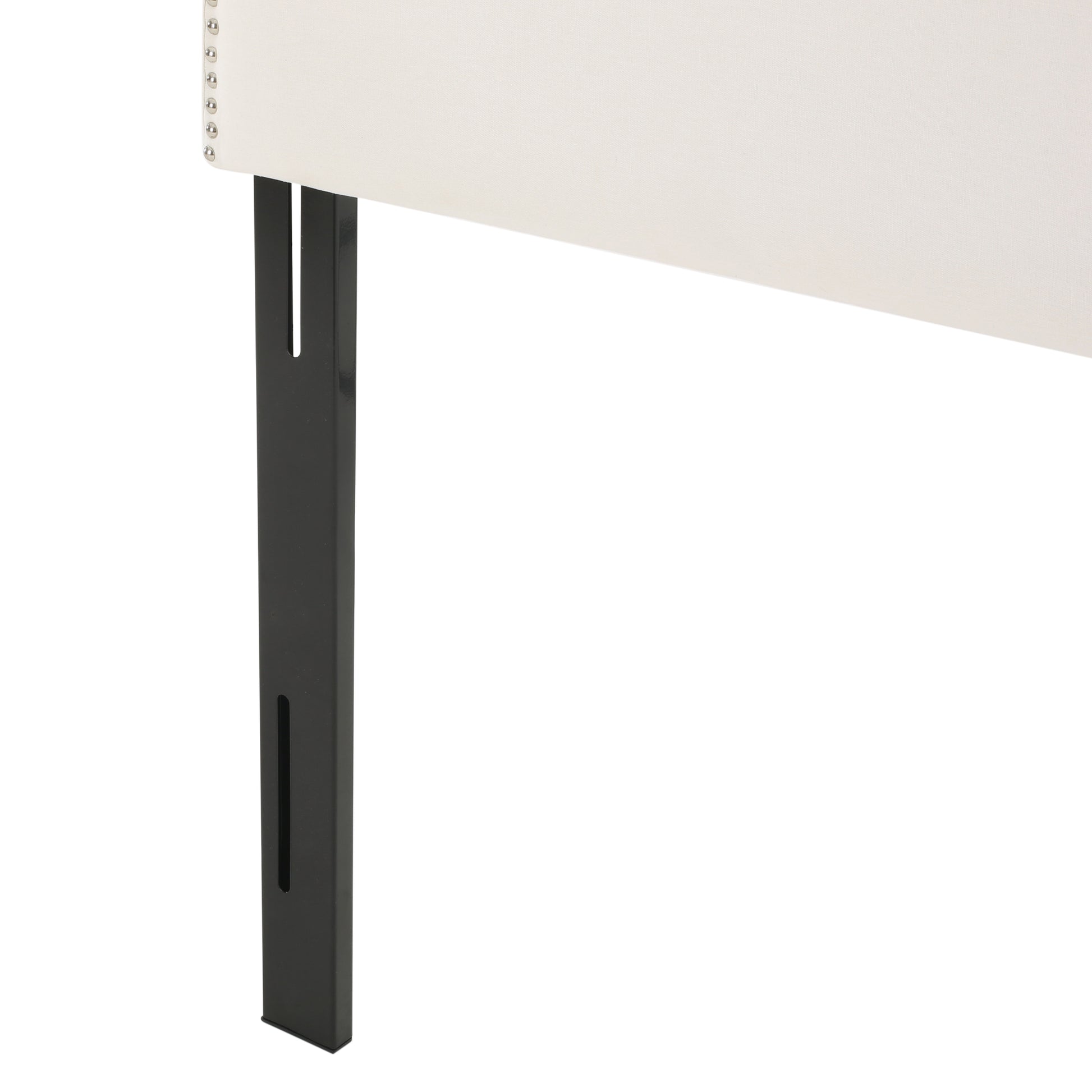 Upholstered headboard detail with nailhead trim and black metal legs