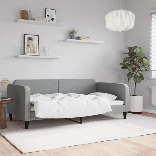 Grey upholstered sofa bed with white bedding