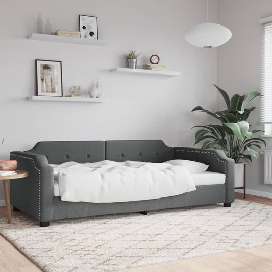 Dark grey tufted daybed with white bedding and studded arms