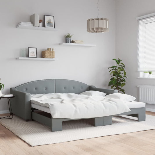 Tufted grey sofa bed with white bedding pulled out