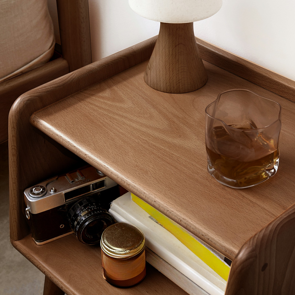 Midcentury modern walnut bedside table with a glass of amber liquid