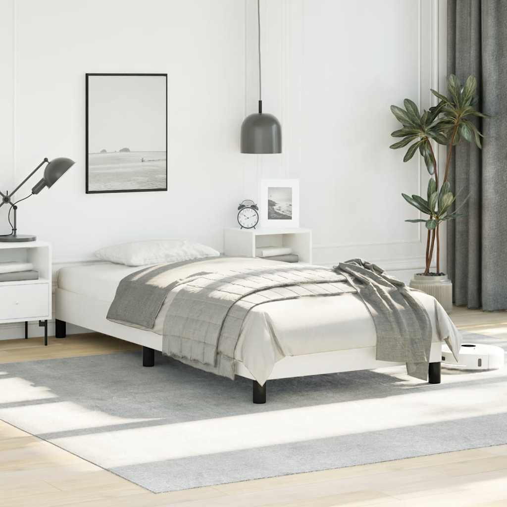 Minimalist white single bed frame with black legs and grey bedding