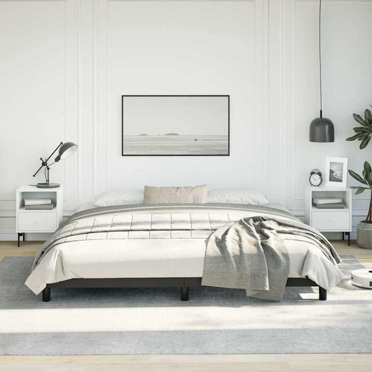 Modern black metal platform bed frame with white bedding and grey throw blanket