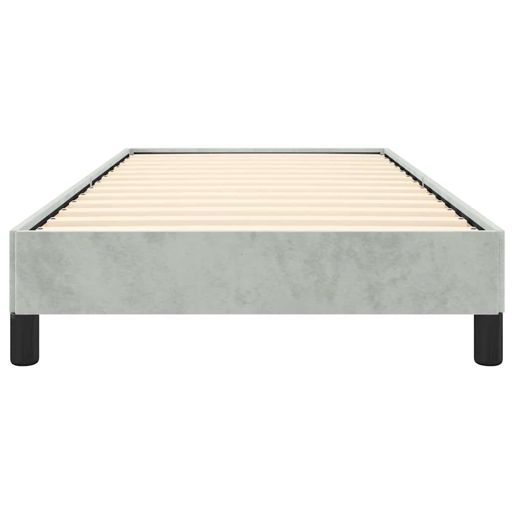 Gray upholstered single bed frame with white bedding and a throw blanket