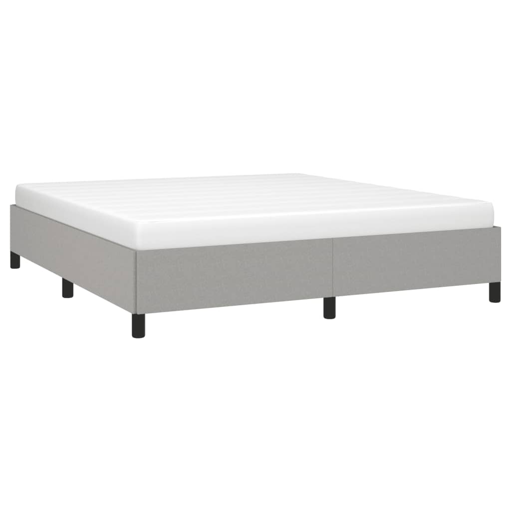 Light grey fabric upholstered bed frame with white mattress and black legs